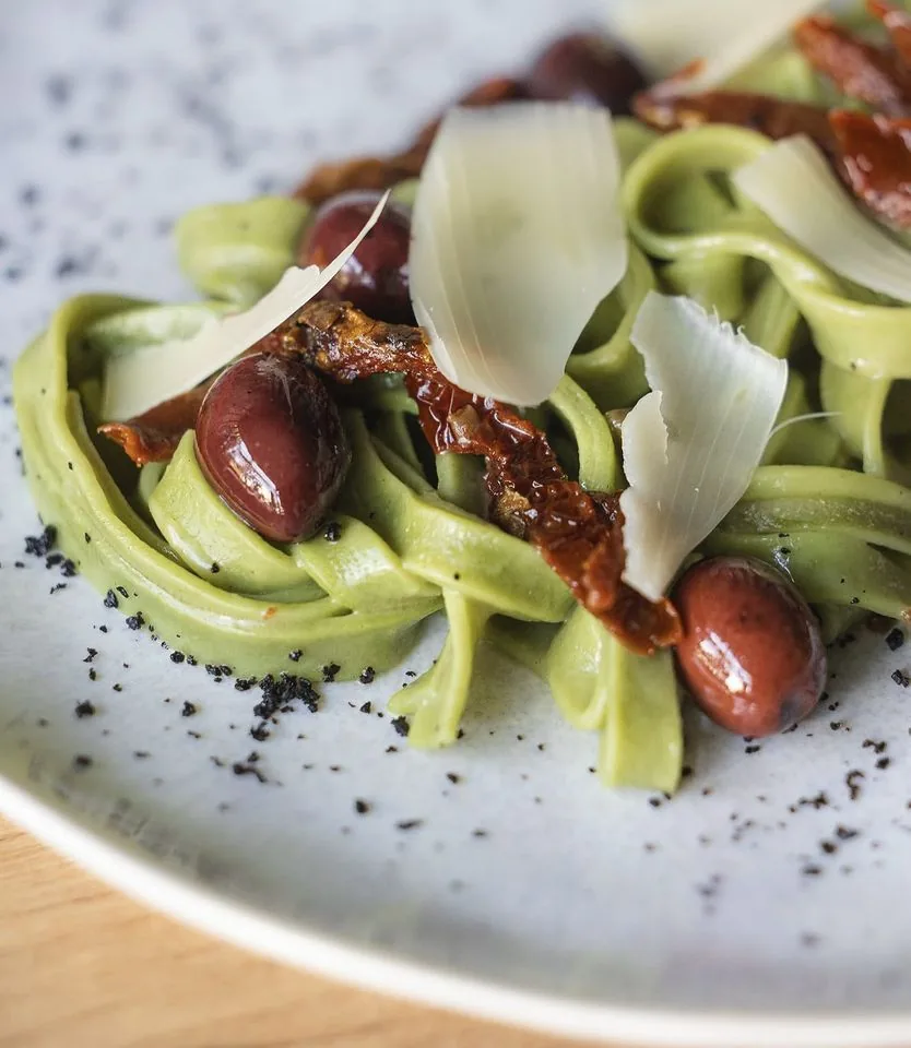 Pasta fresca — Zielone tagliatelle, oliwki, suszone pomidory i płatki sera.